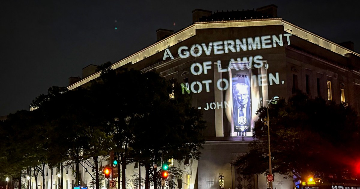 John Adams quote projected on DOJ building in protest of $1.8B fund